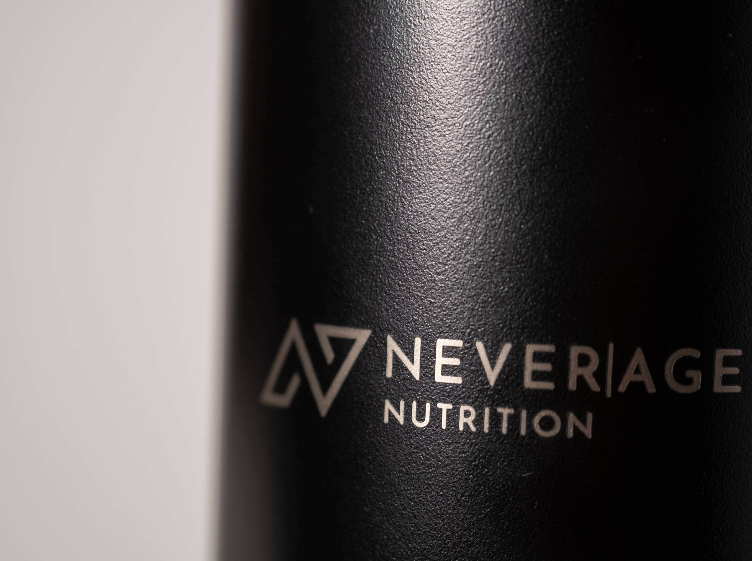 Never Age Logo auf dem schwarzen Thermo-Tumbler
