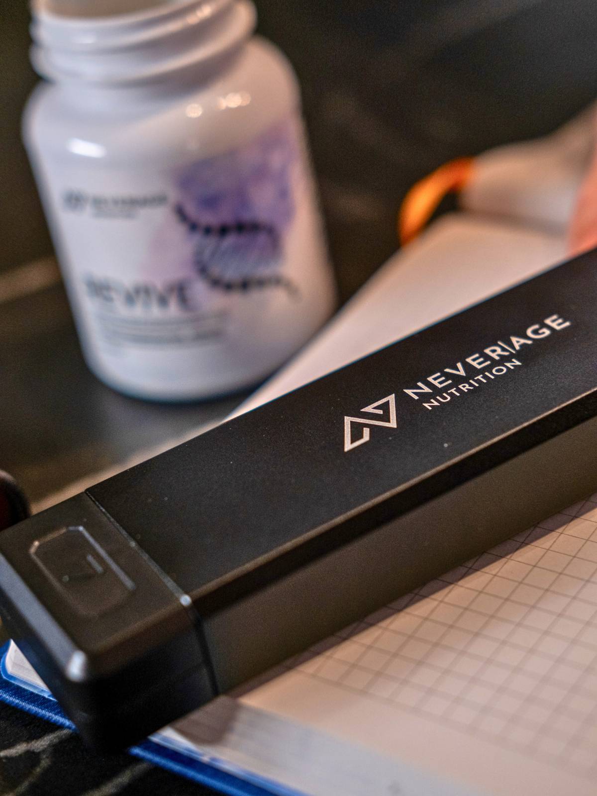 Never Age Pillendose auf dem Schreibtisch neben REVIVE